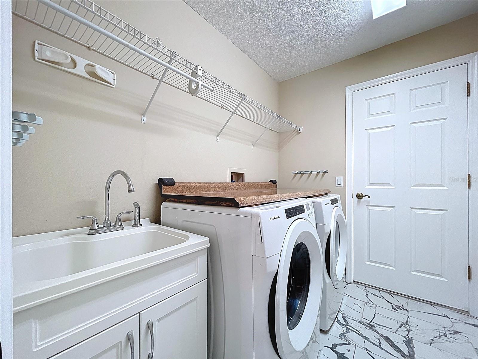 Separate utility room with sink and folding counter