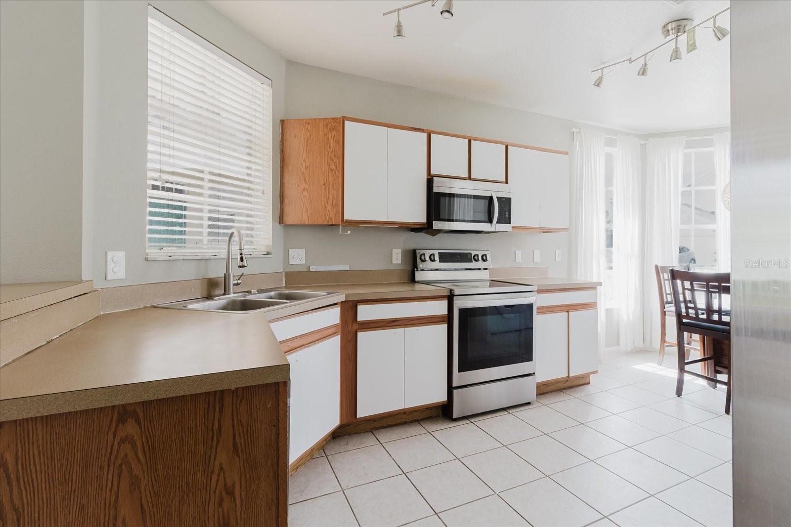 Eat In Kitchen With Tile Floors and Stainless Steel Appliances, And The Washer & Dryer Are In The Kitchen - Overlooks Into The Living Room 1