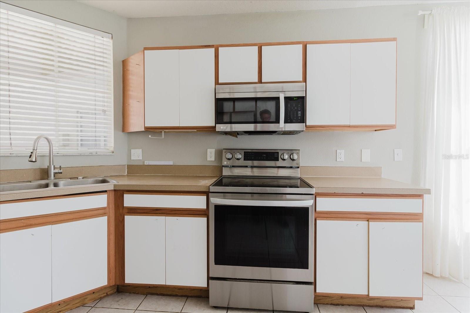 Eat In Kitchen With Tile Floors and Stainless Steel Appliances, And The Washer & Dryer Are In The Kitchen - Overlooks Into The Living Room 3