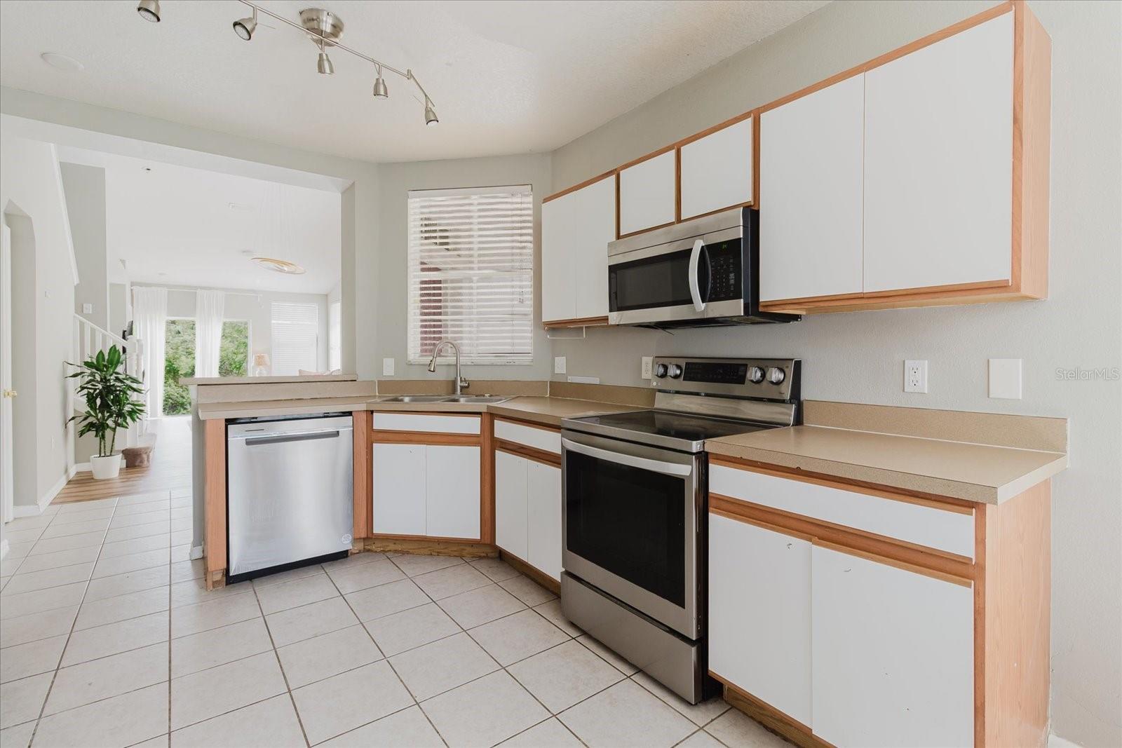 Eat In Kitchen With Tile Floors and Stainless Steel Appliances, And The Washer & Dryer Are In The Kitchen - Overlooks Into The Living Room 4