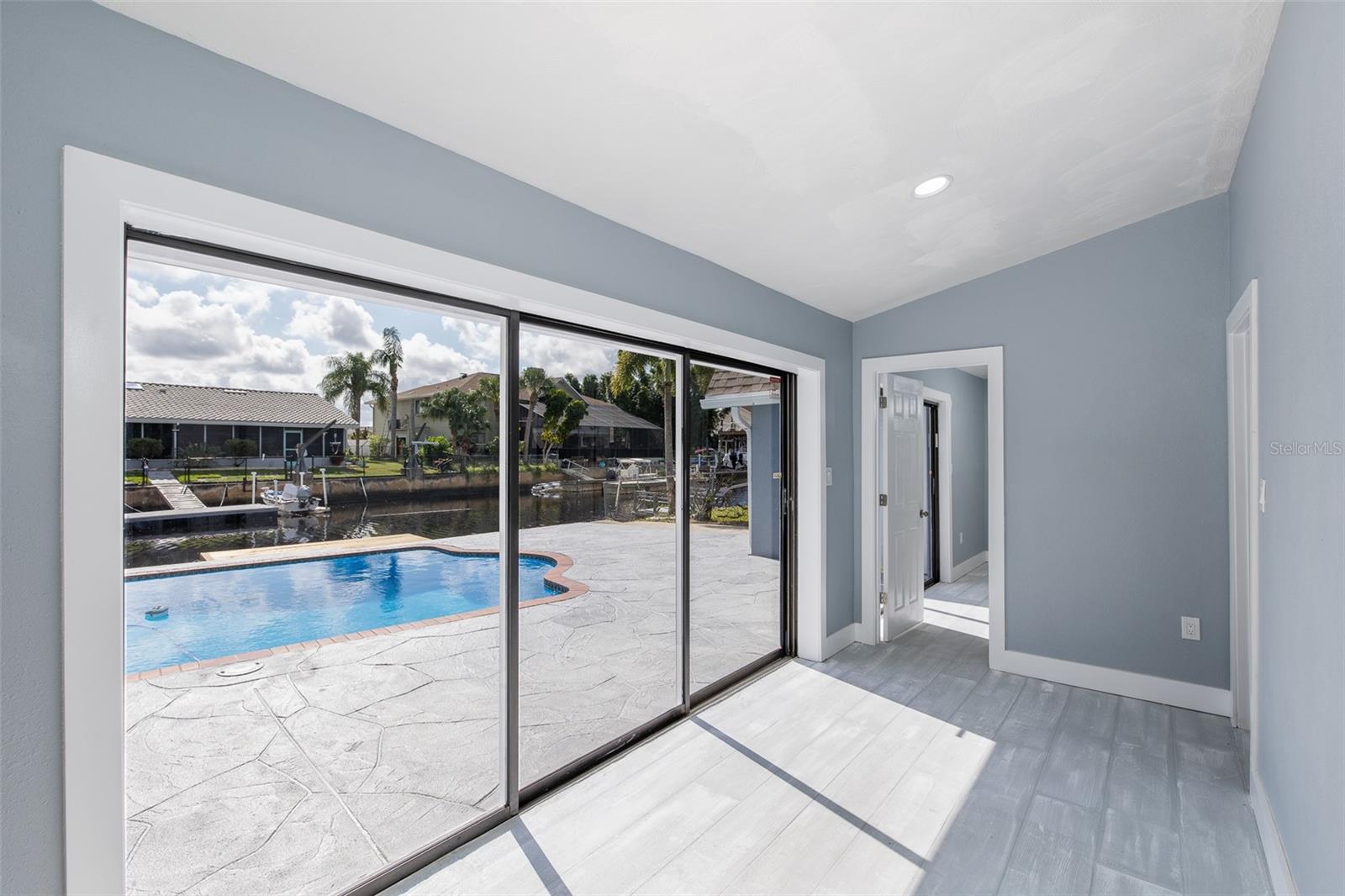 New sliding glass doors overlooking the oversized pool deck