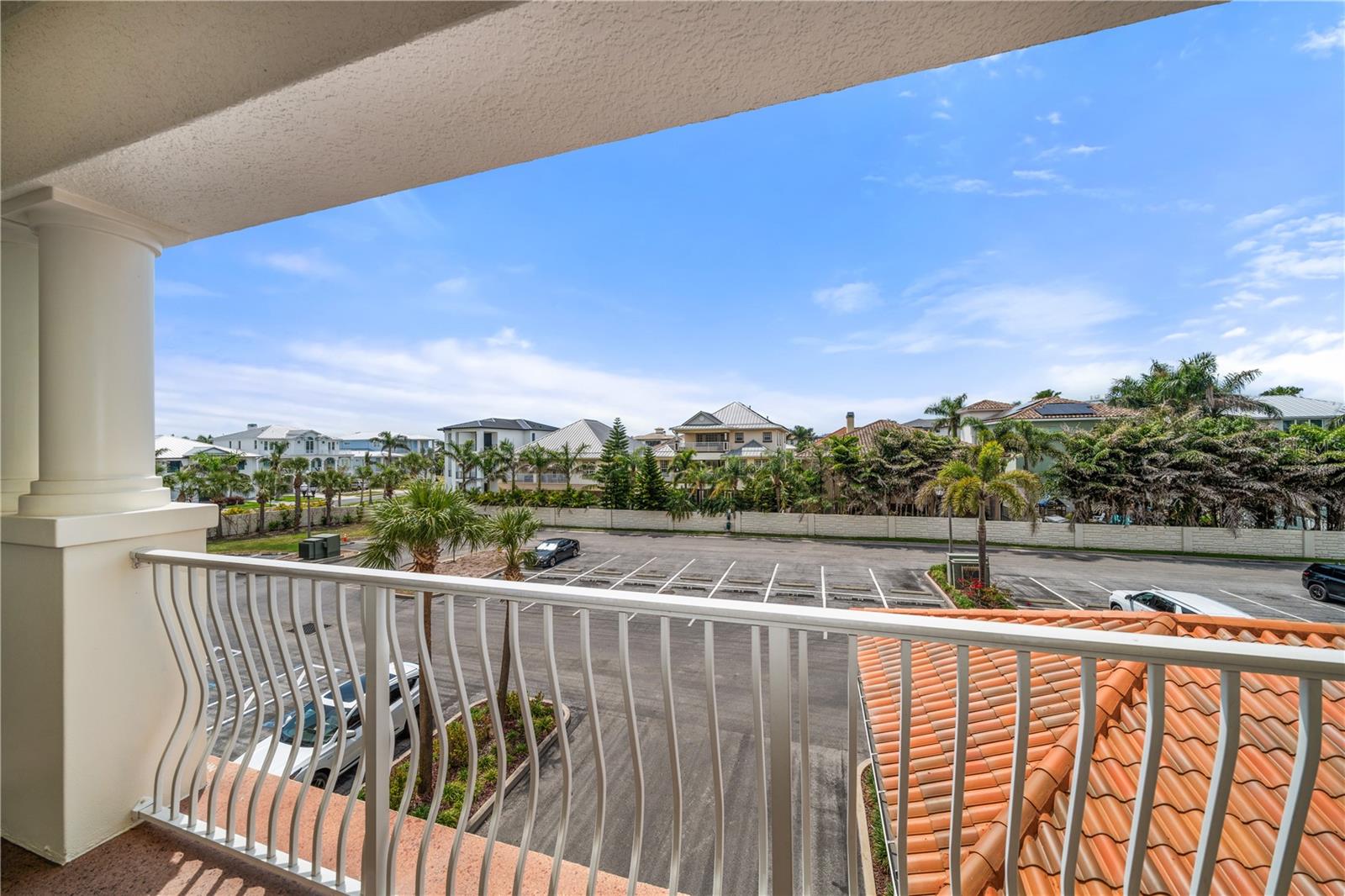 Front exterior balcony to front door . You can see the abundance of visitor parking great for family gatherings and very unique covered feature of this great community as beach parking is limited in most condo communities