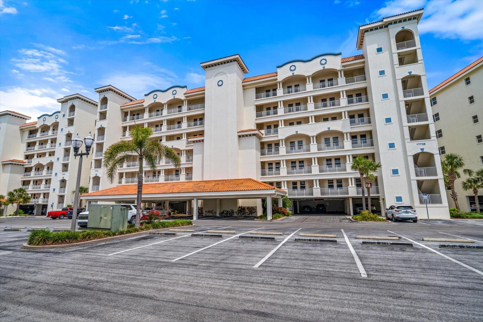 Front exterior offers under building assigned parking and an abundance of visitor parking in the gated community