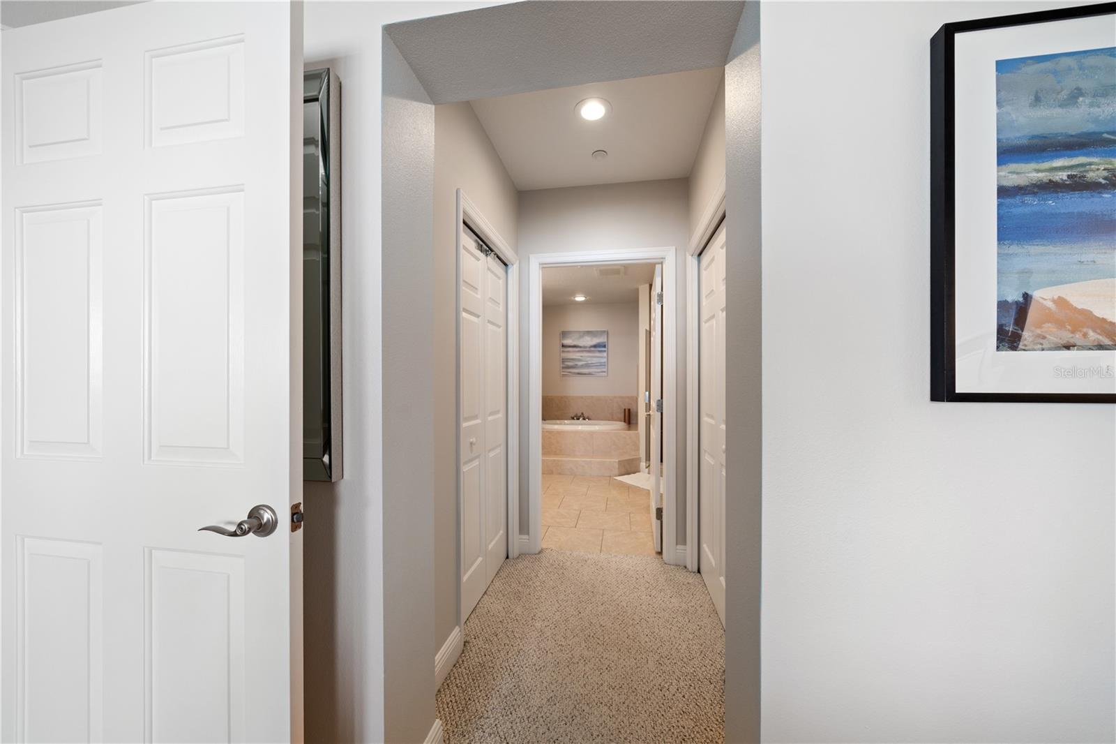Primary em-suite hallway to walk in closets and master bathroom