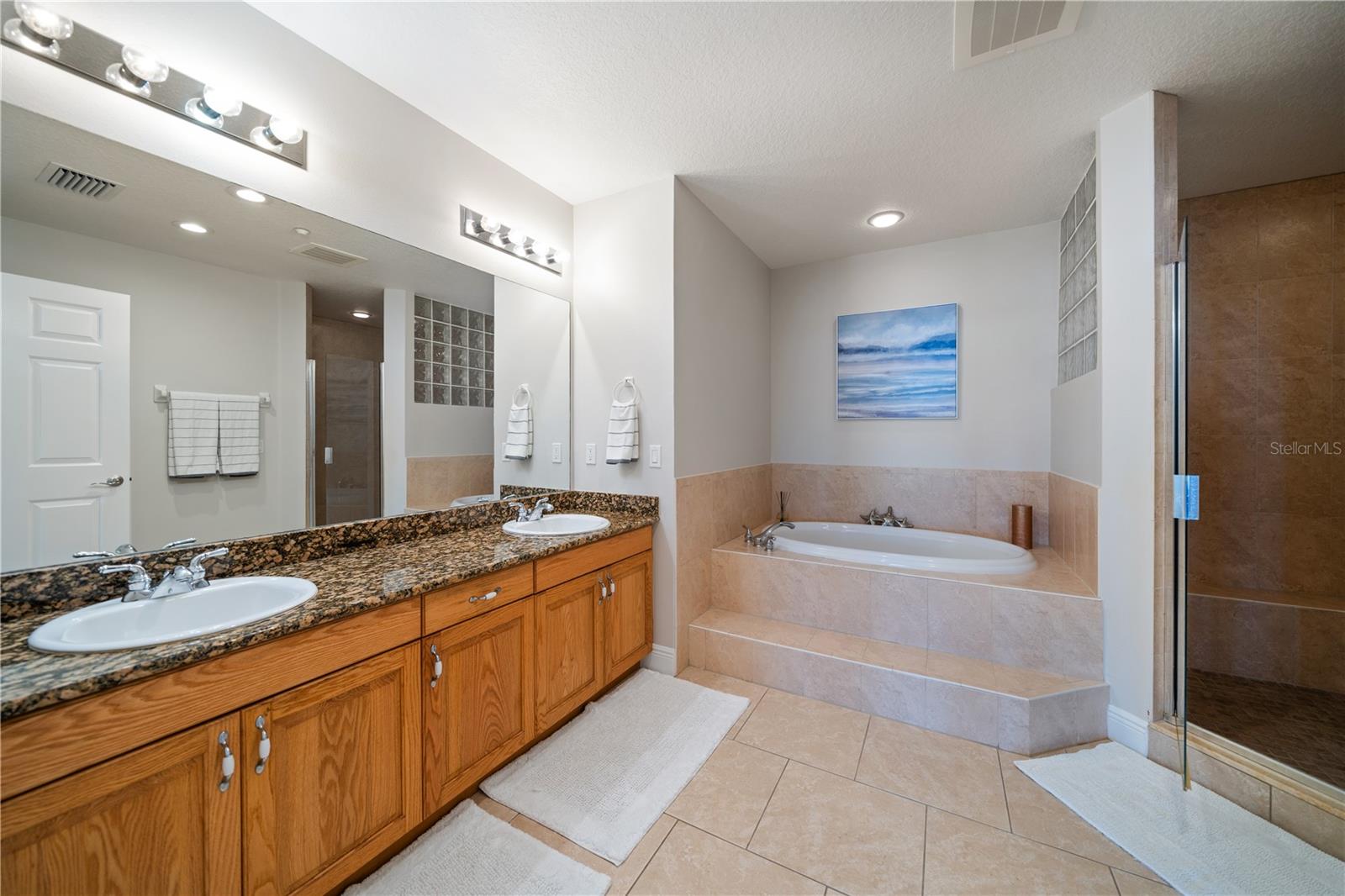 Primary Bathroom #3 has garden tub, stand in tiled shower , dual sinks, and private powder room .