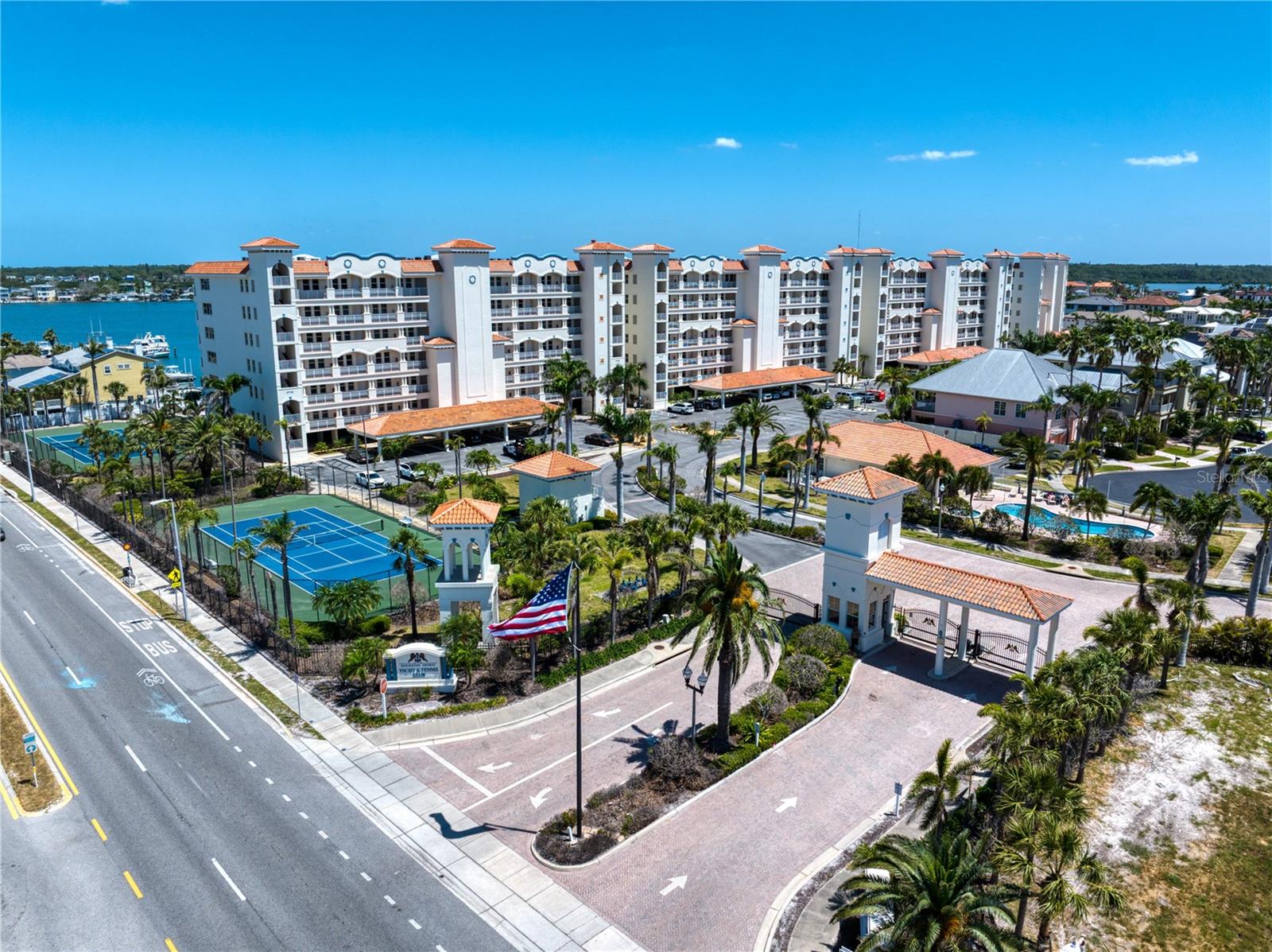 Aerial view of Grand entry gated community spans over an acre for waterfront condominium, mid rises and community residential single-family homes all gated