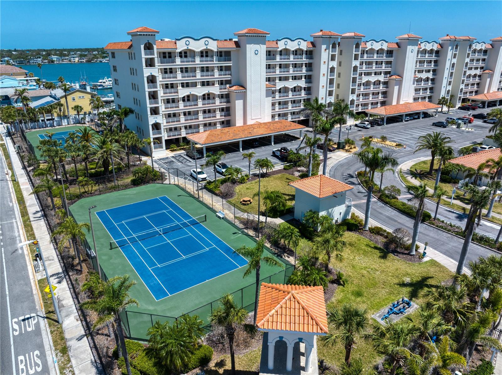 Aerial views that are amenities show two tennis courts which are lit at night