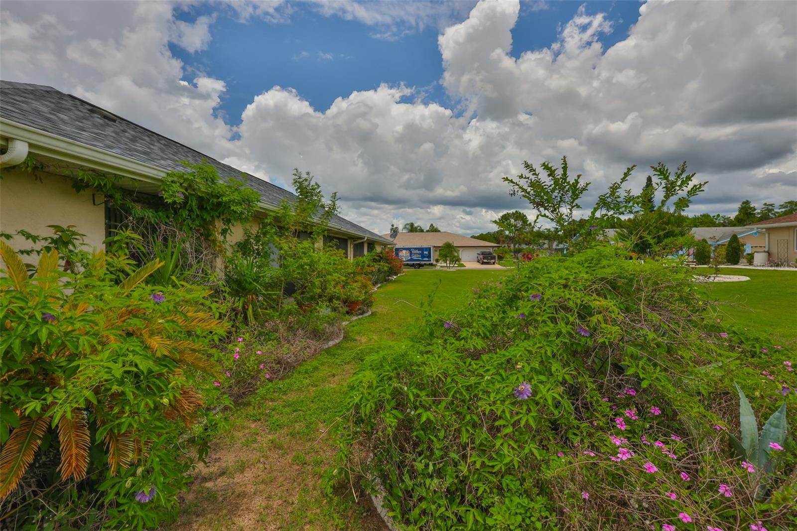Backyard has mature landscaping and custom curbing around all plant beds