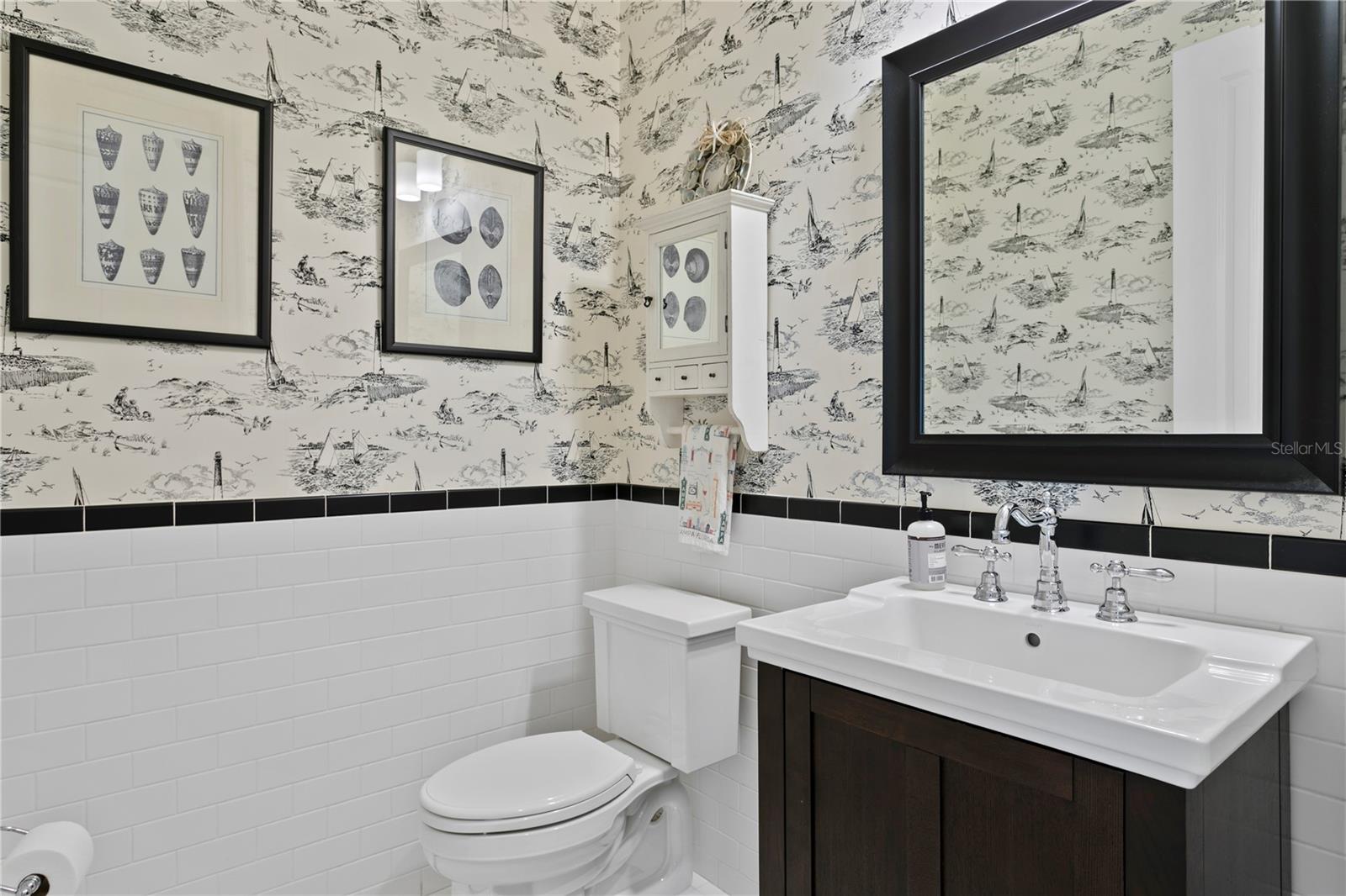 Crisp tile, elegant fixtures, and vintage wallpaper bring classic style to this powder room.