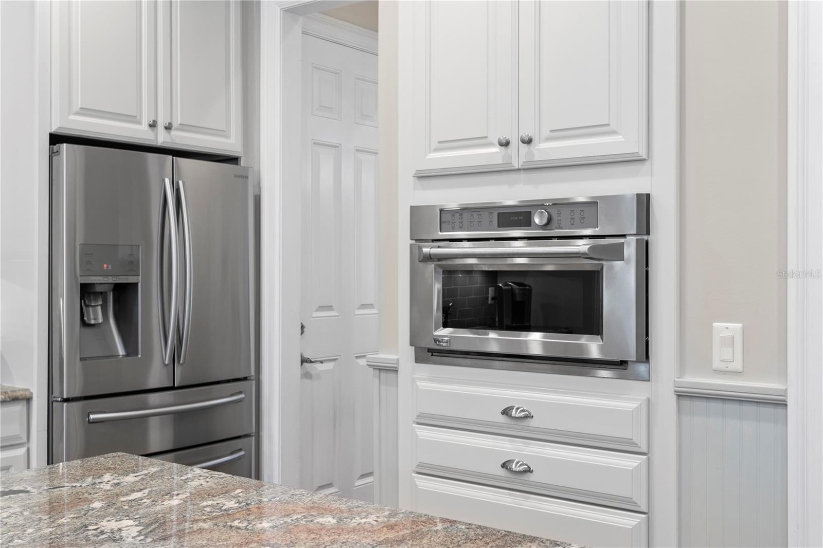 The kitchen features a GE Monogram gas range and Advantium microwave/wall oven.