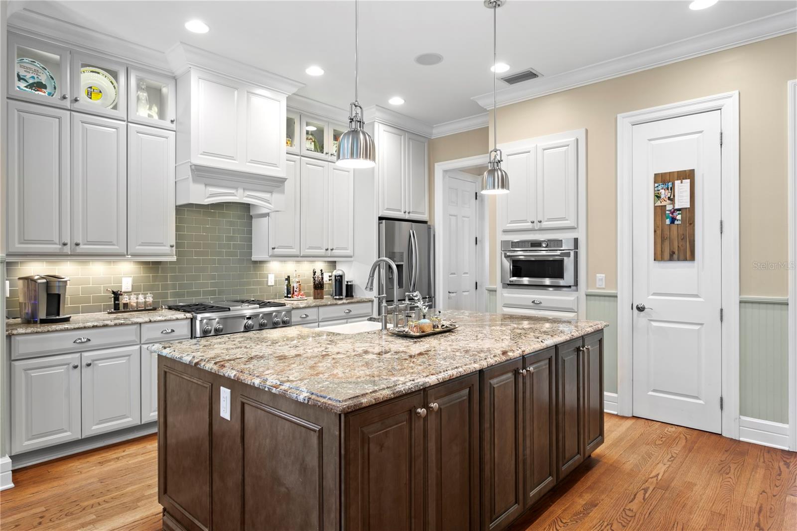 The beautifully designed gourmet kitchen features granite countertops, custom cabinetry, stainless steel appliances and a spacious island perfect for every day living and entertaining.