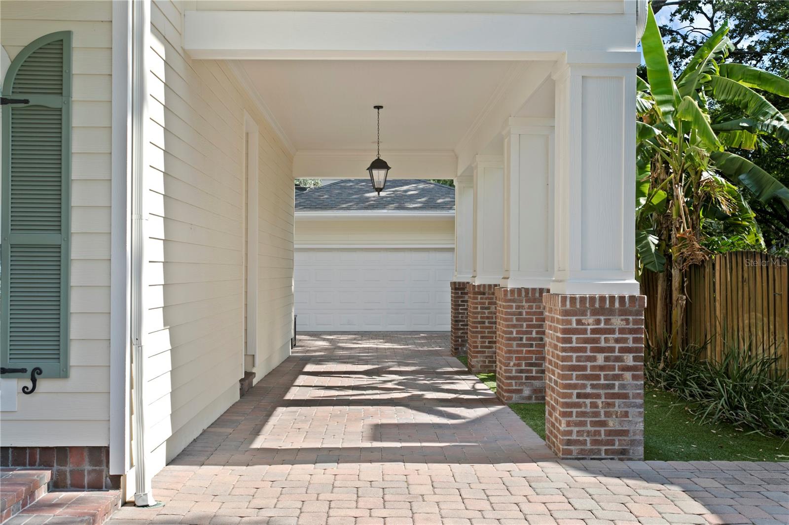 A wide driveway and porte cochere provide convenience, charm, and room for multiple vehicles.
