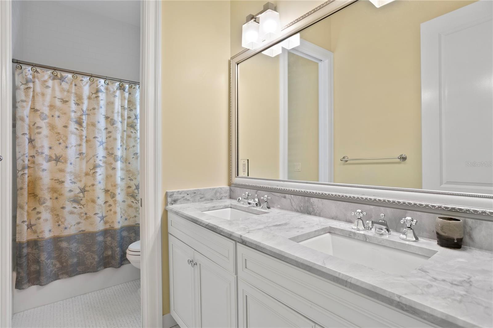 This Jack and Jill bathroom features dual sinks and a large vanity.