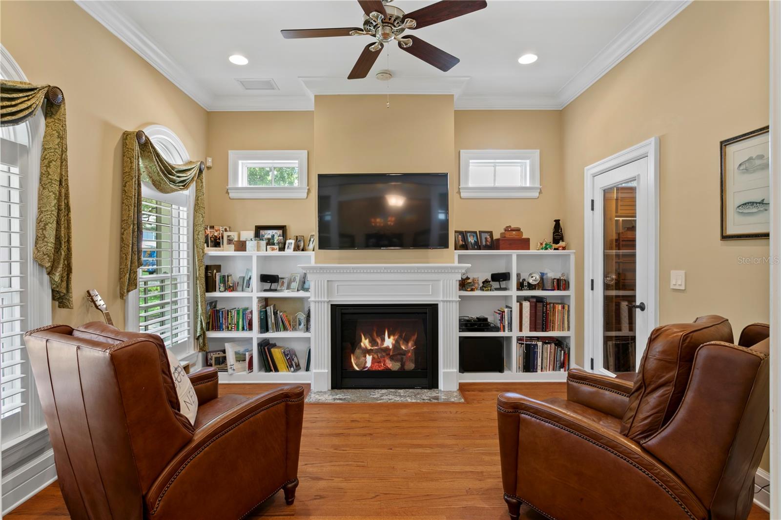 The gas fireplace serves as the centerpiece of this versatile den, a warm and inviting space that can function beautifully as a formal living room, reading nook, or even a private home office.