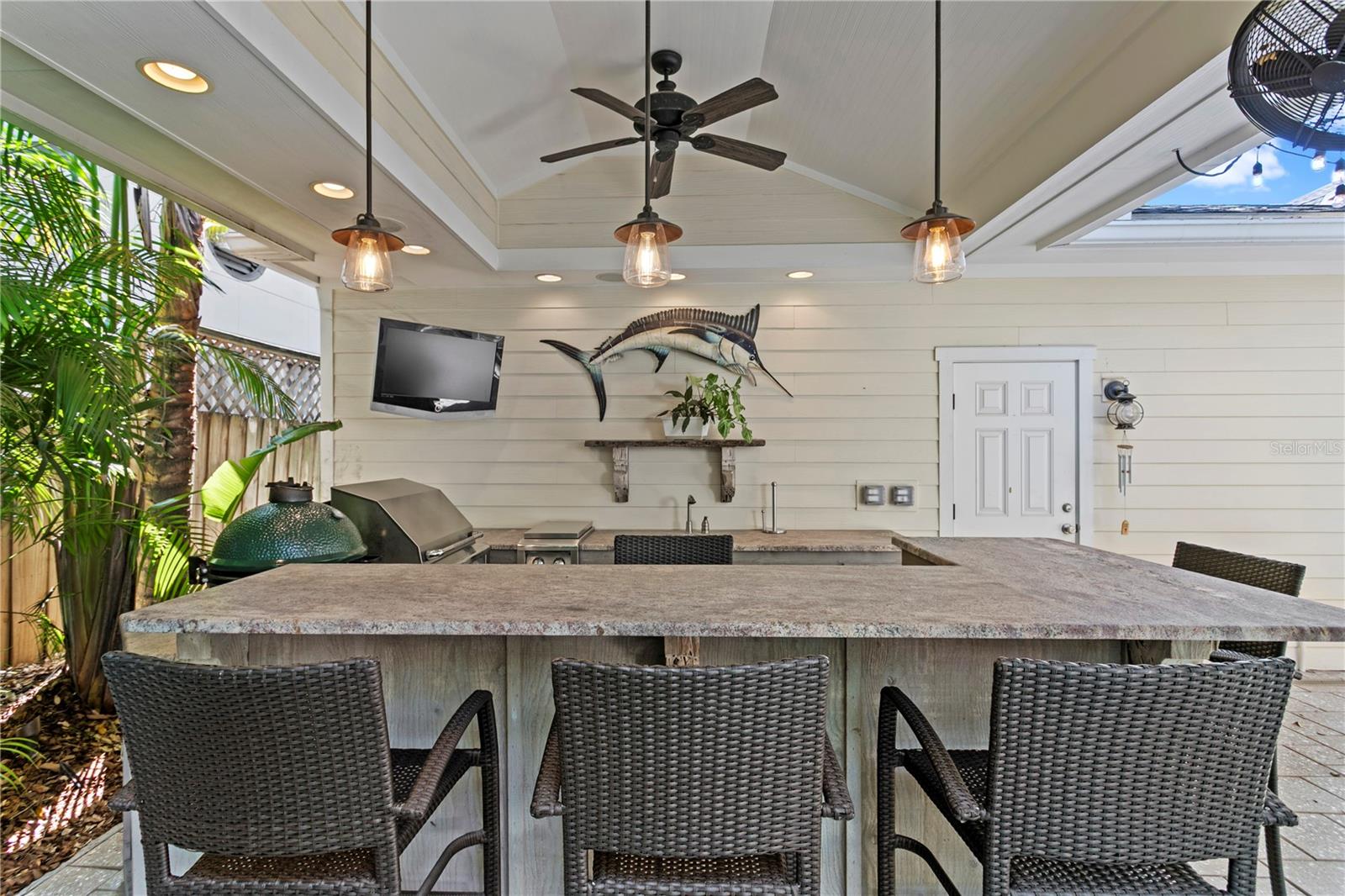 Cedar cabinets, granite countertops with a leather/textured finish and pecky cypress reclaimed shelving are a few of the details you will find in this amazing outdoor kitchen.