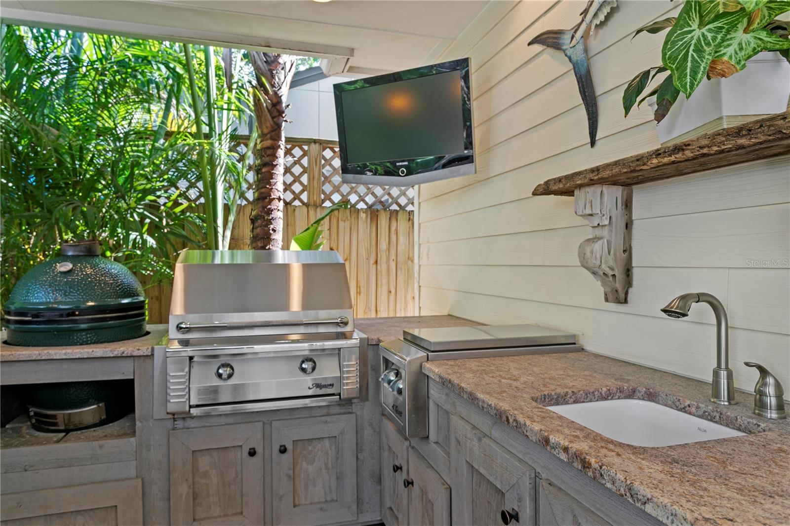 The outdoor kitchen is complete with the large model Big Green Egg, an Alfresco gas grill and side burner, plus a convenient sink for prep work and easy clean up.