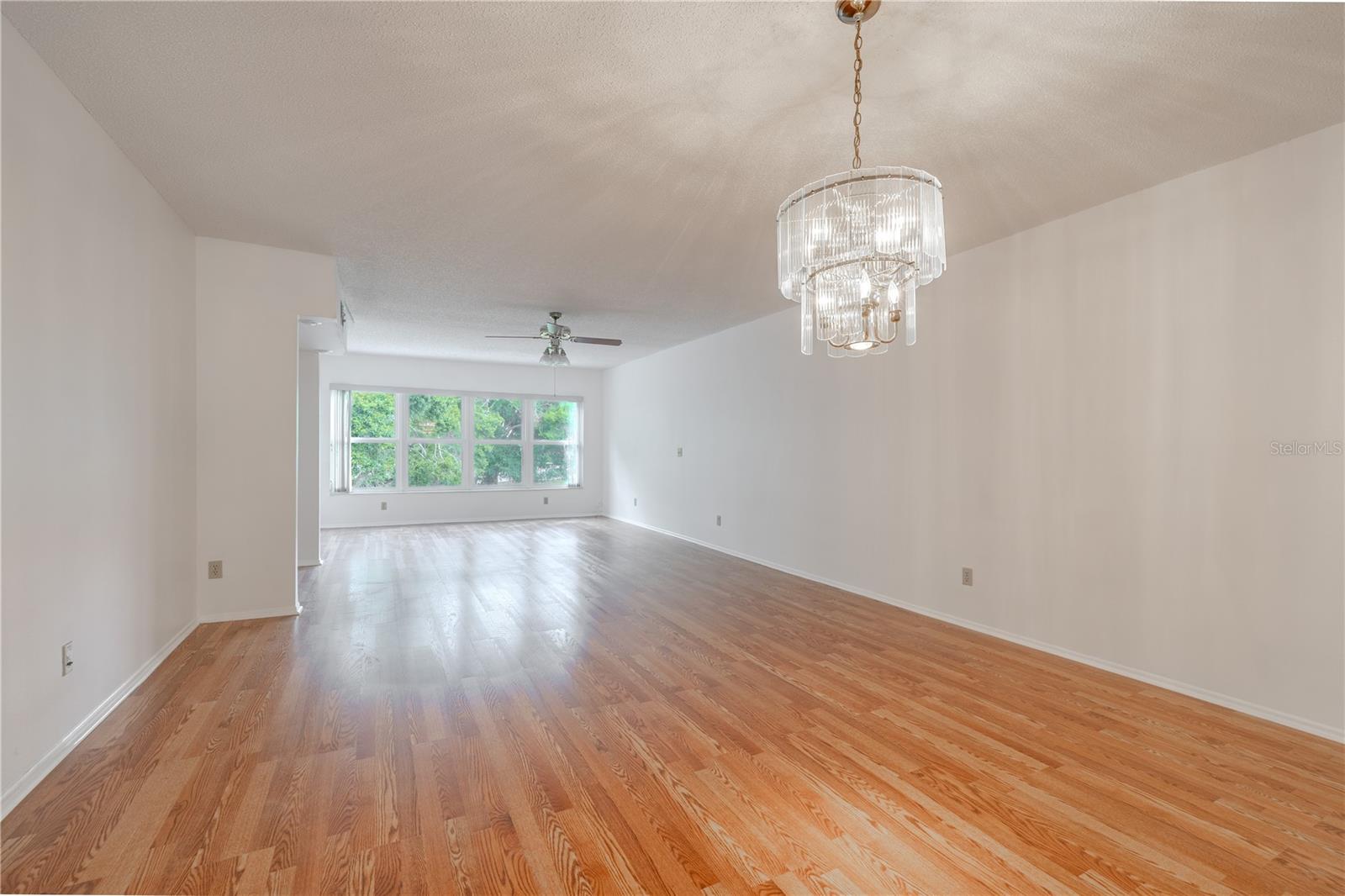 The dining room features a pendant chandelier, freshly painted neutral tone walls and new wood laminate flooring.