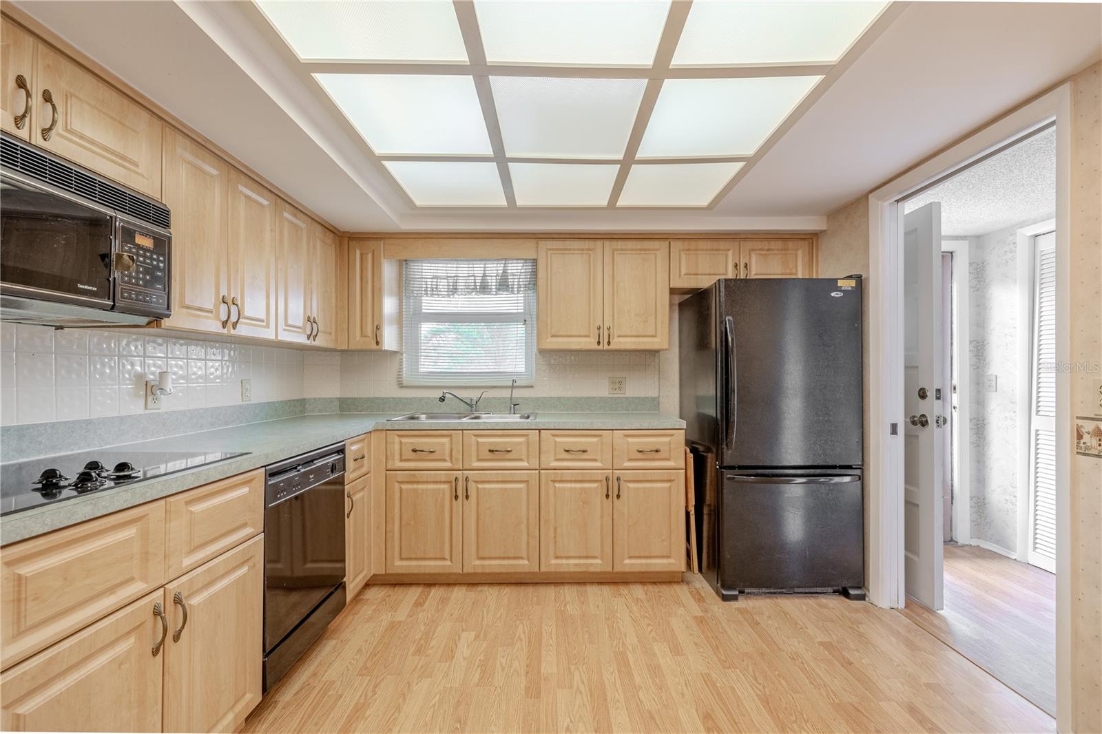 The kitchen features a double basin stainless steel sink that sits beneath a window.