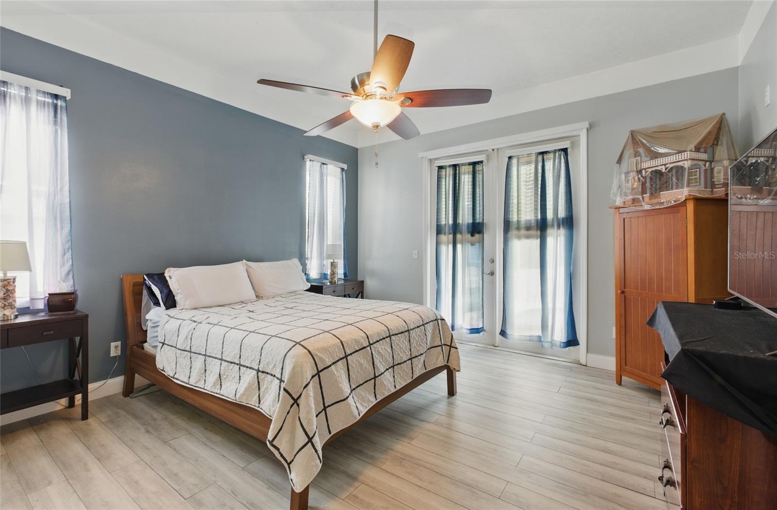 Primary bedroom with double doors out to the pool area