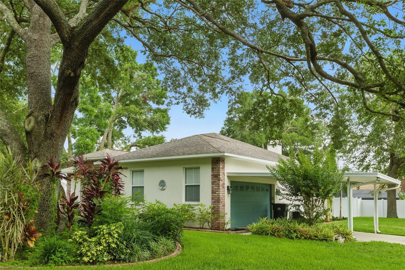 Two car attached garage with parking and covered carport