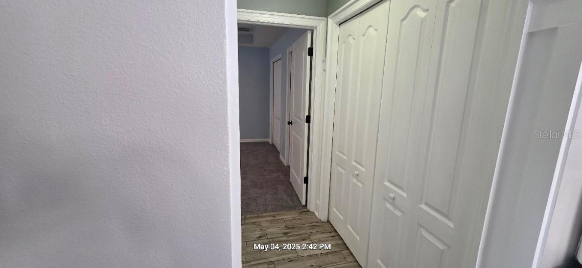 HALLWAY TO PRIMARY BEDROOM & LAUNDRY DOORS
