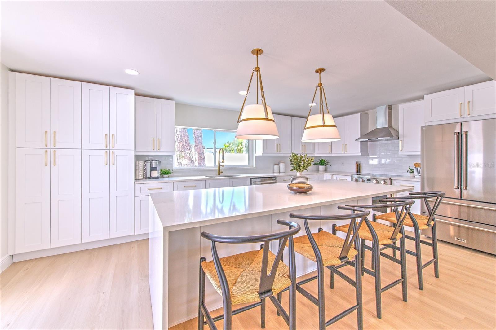 Waterfall quartz edge island and built in cabinetry for pantry