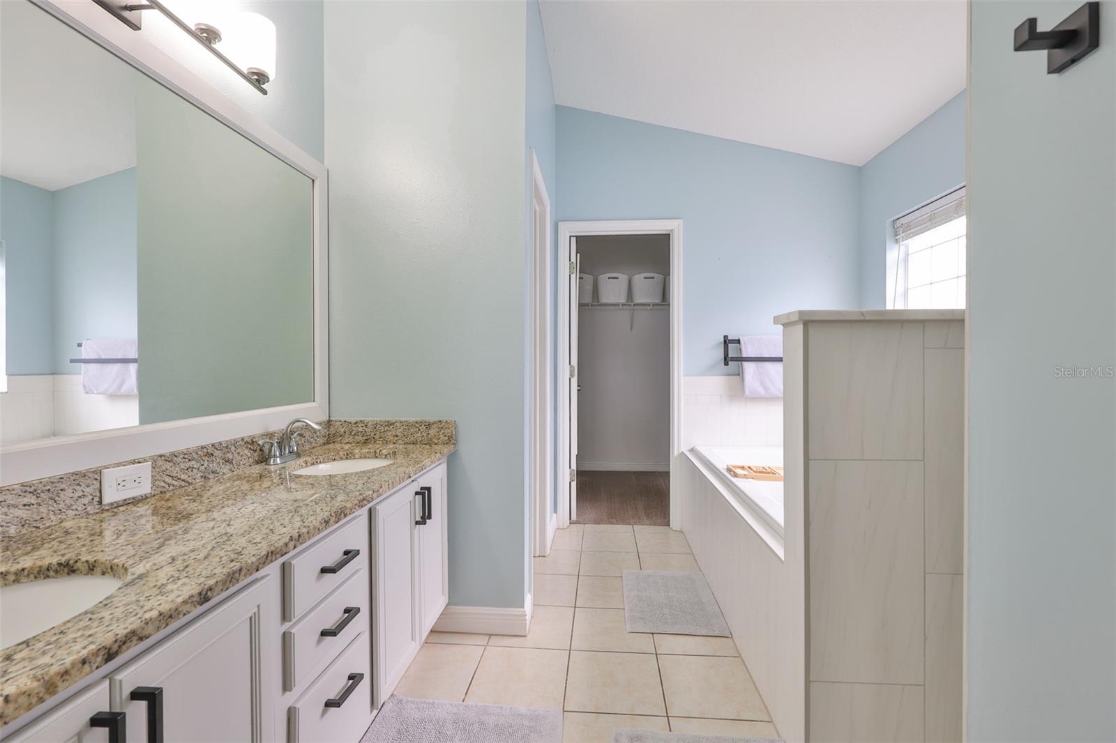 New light fixtures over the vanity with dual sinks in granite counters