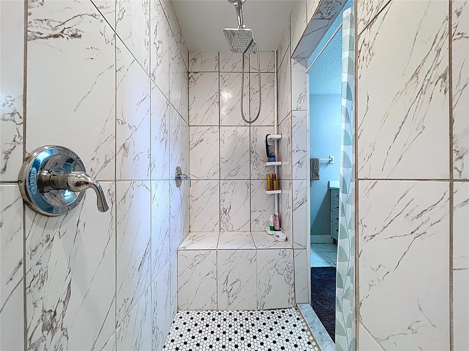 Updated Primary bathroom with oversized walk-in shower featuring dual shower heads.