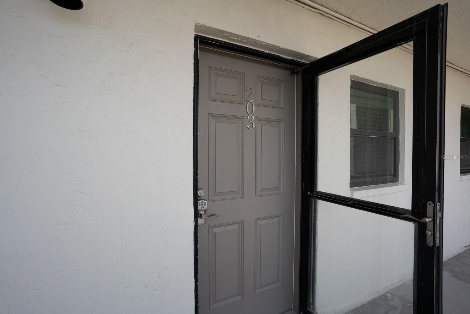 Entrance to Unit 203 with a screen door to enjoy the gulf breezes