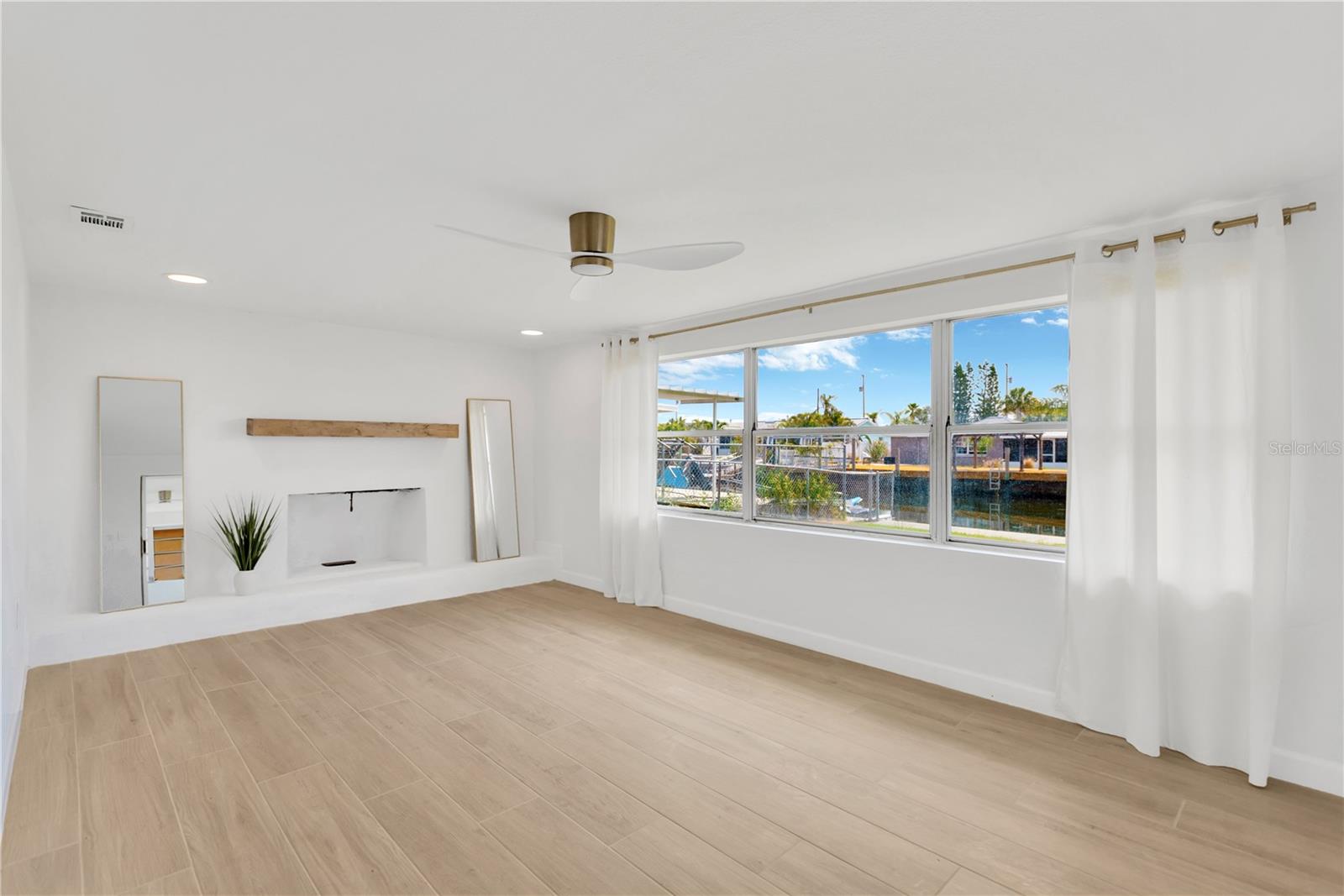 Family room offers abundance of natural light with windows overlooking canal waters.  Accent shelf and modern designer fan complete the ambience.