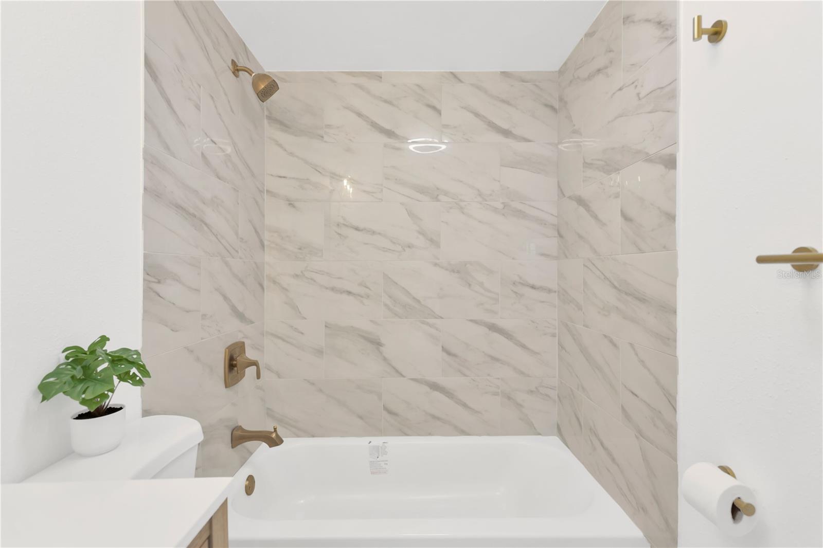 Beautiful floor to ceiling tile walls grace this tub/shower combination with modern finishes.  Indulge in Luxury.