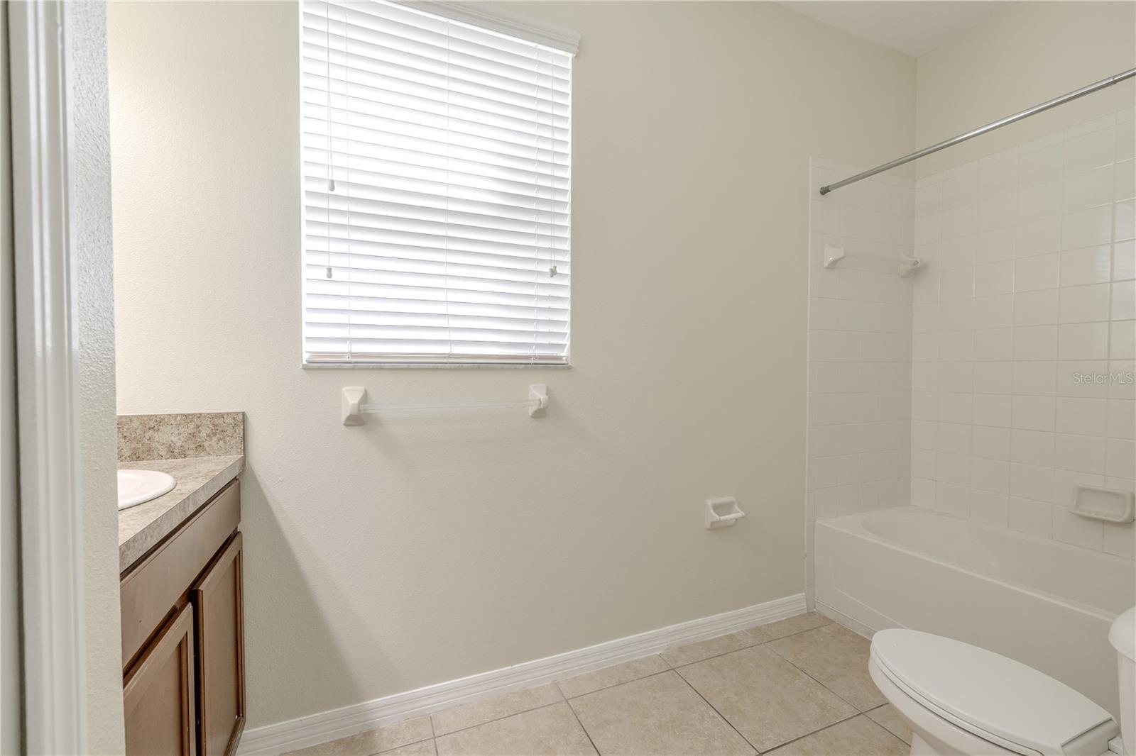 The 3rd bathroom (first floor) features a tile floor, a mirrored vanity with storage and a tub with shower.