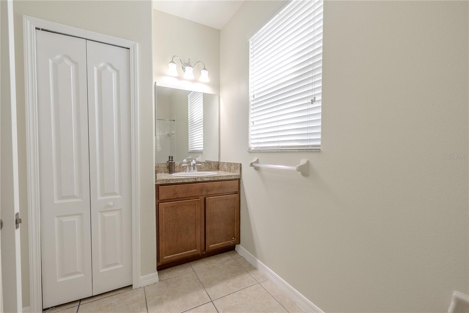 The 3rd bathroom features a mirrored vanity with storage and down-light fixture.