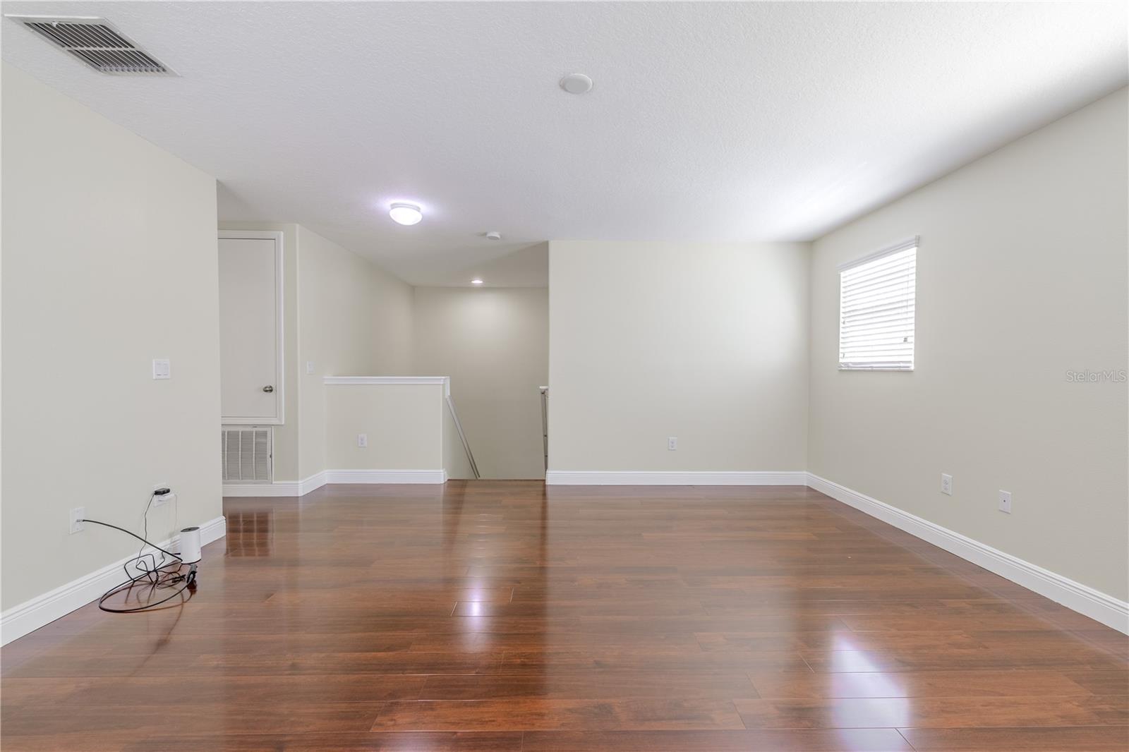 The 2nd floor landing features a spacious loft with wood floor. Ideal for media room, home gym, game room or home office.