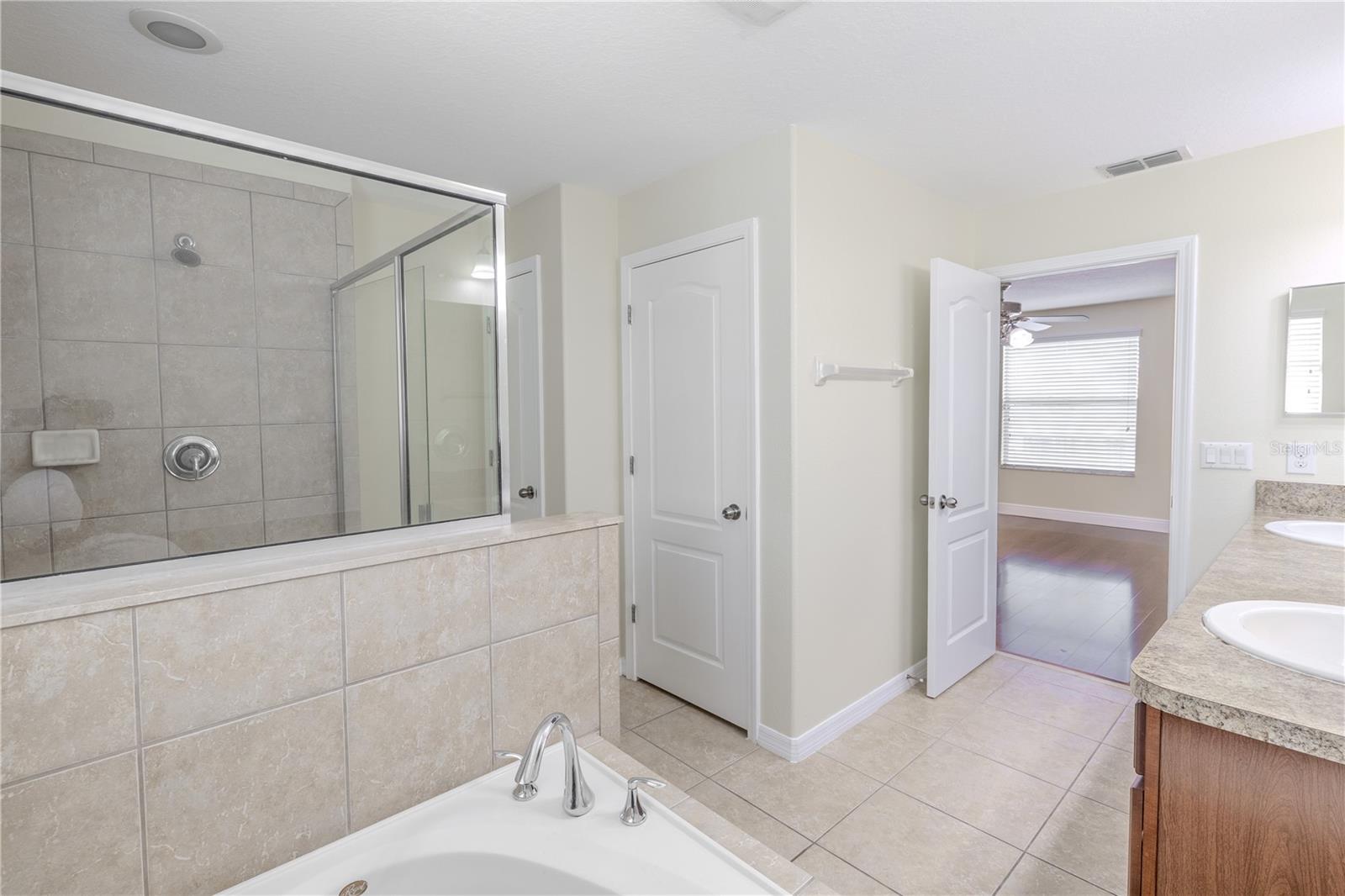 Primary bathroom is bathed in neutral tones