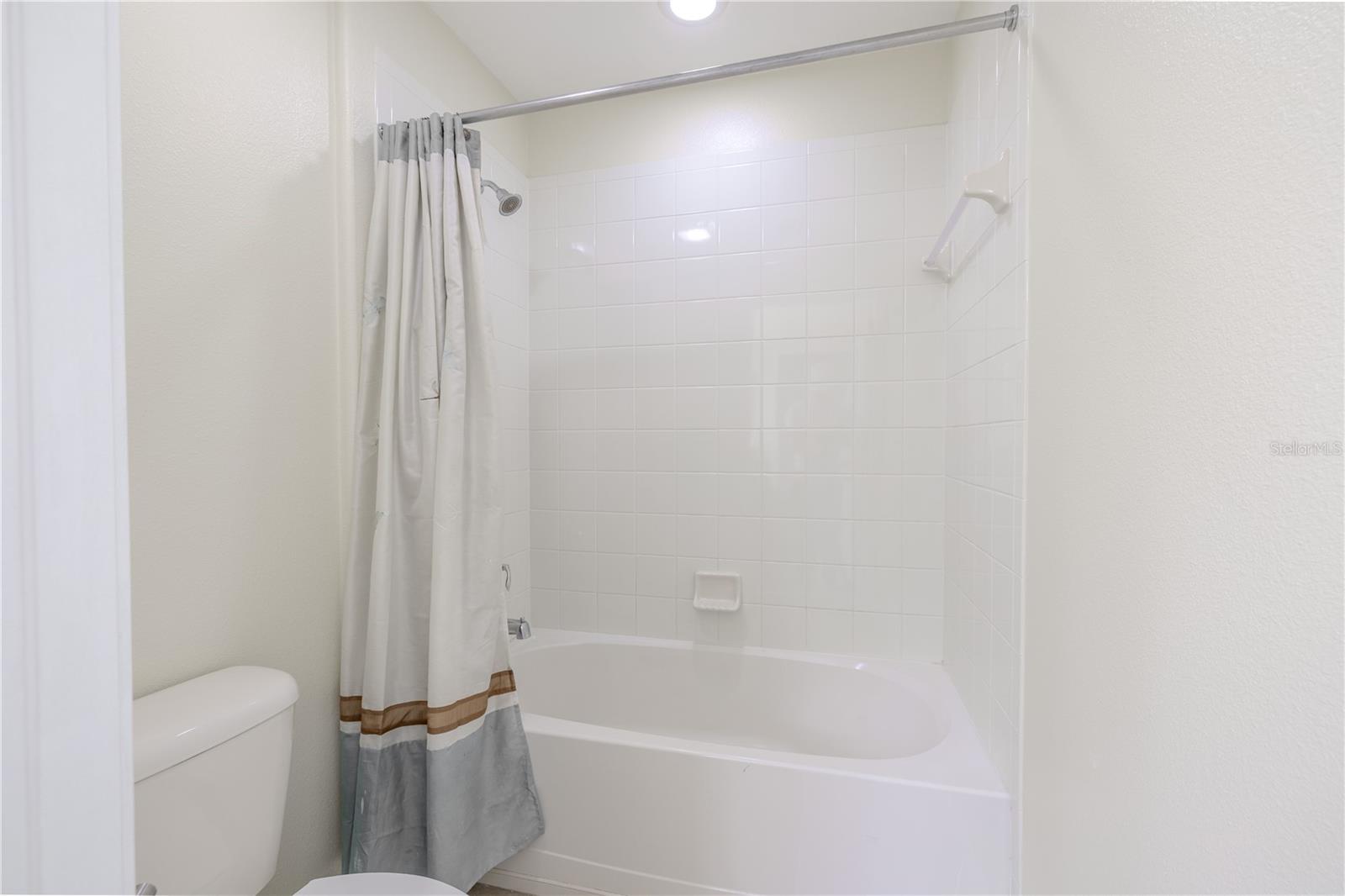 2nd bathroom has a tiled tub with shower.