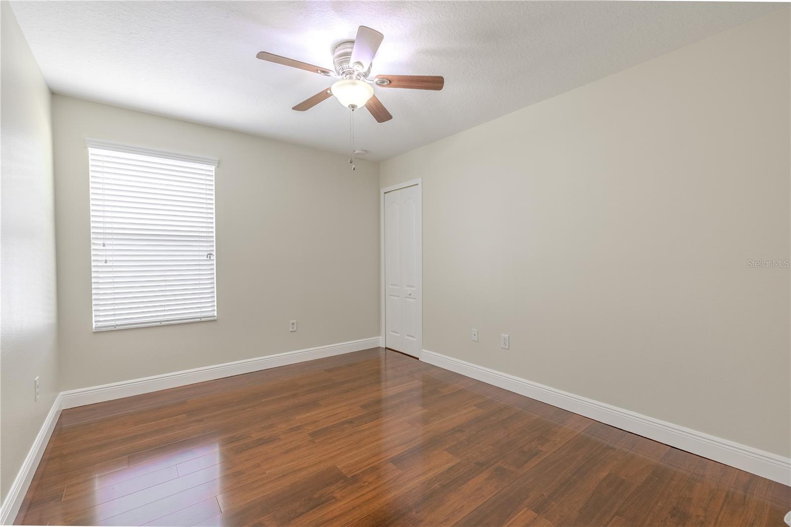 3rd bedroom features a wood floor, a built-in closet and a ceiling fan with light kit.