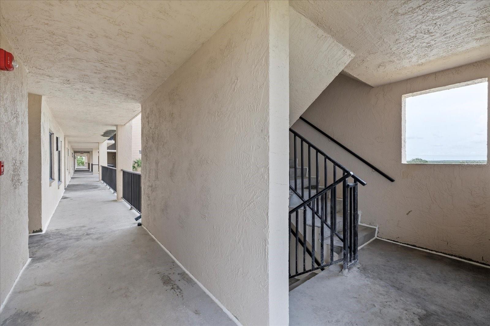 Nearby stairwell for emergencies/elevator on down walkway.