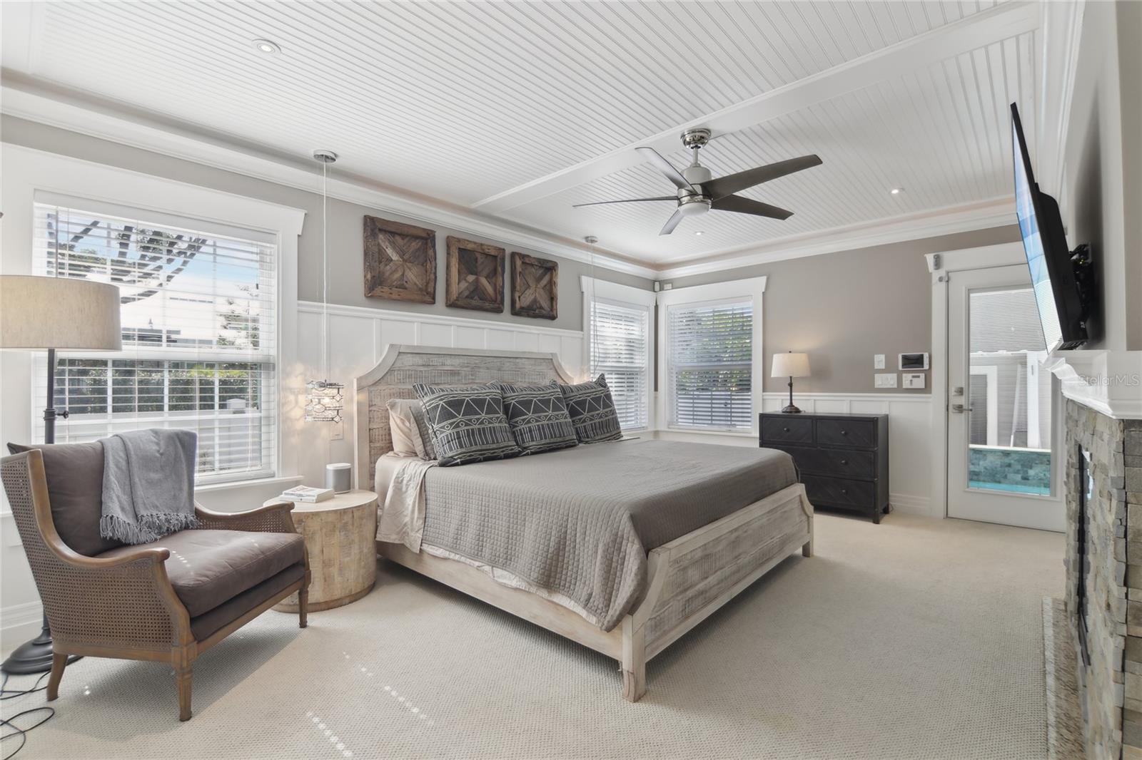 The primary bedroom is on the main level with direct pool access, cove lighting, and a ceiling fan.