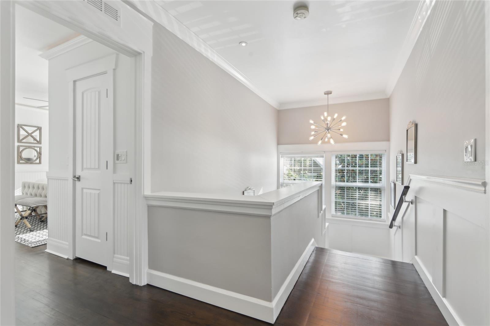 Upstairs features four bedrooms. The hall landing includes an updated light fixture and natural light from the window.