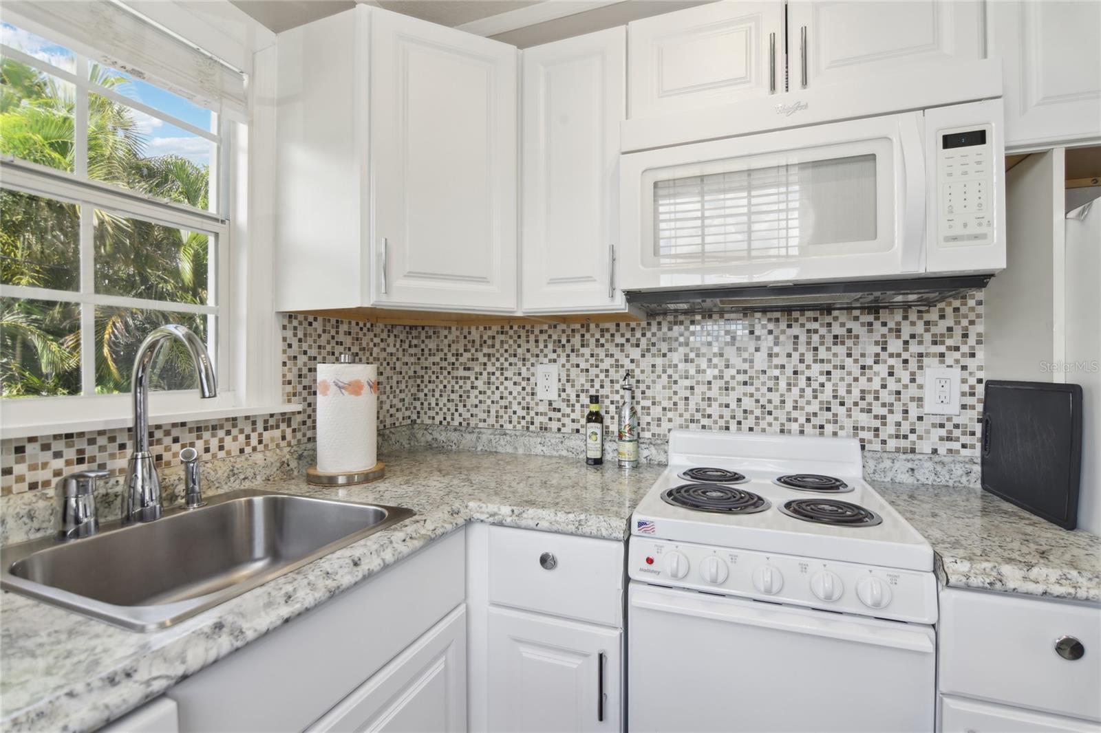 Kitchen in the ADU features a range, microwave, refrigerator, sink, and dishwasher.