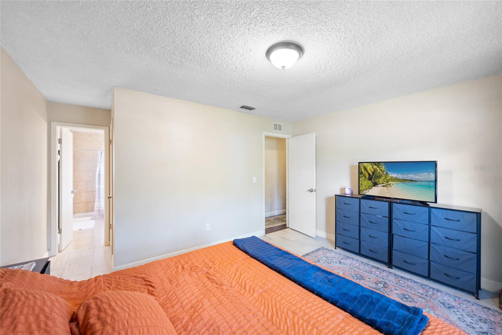 remodeled primary bath with granite counters and tile shower