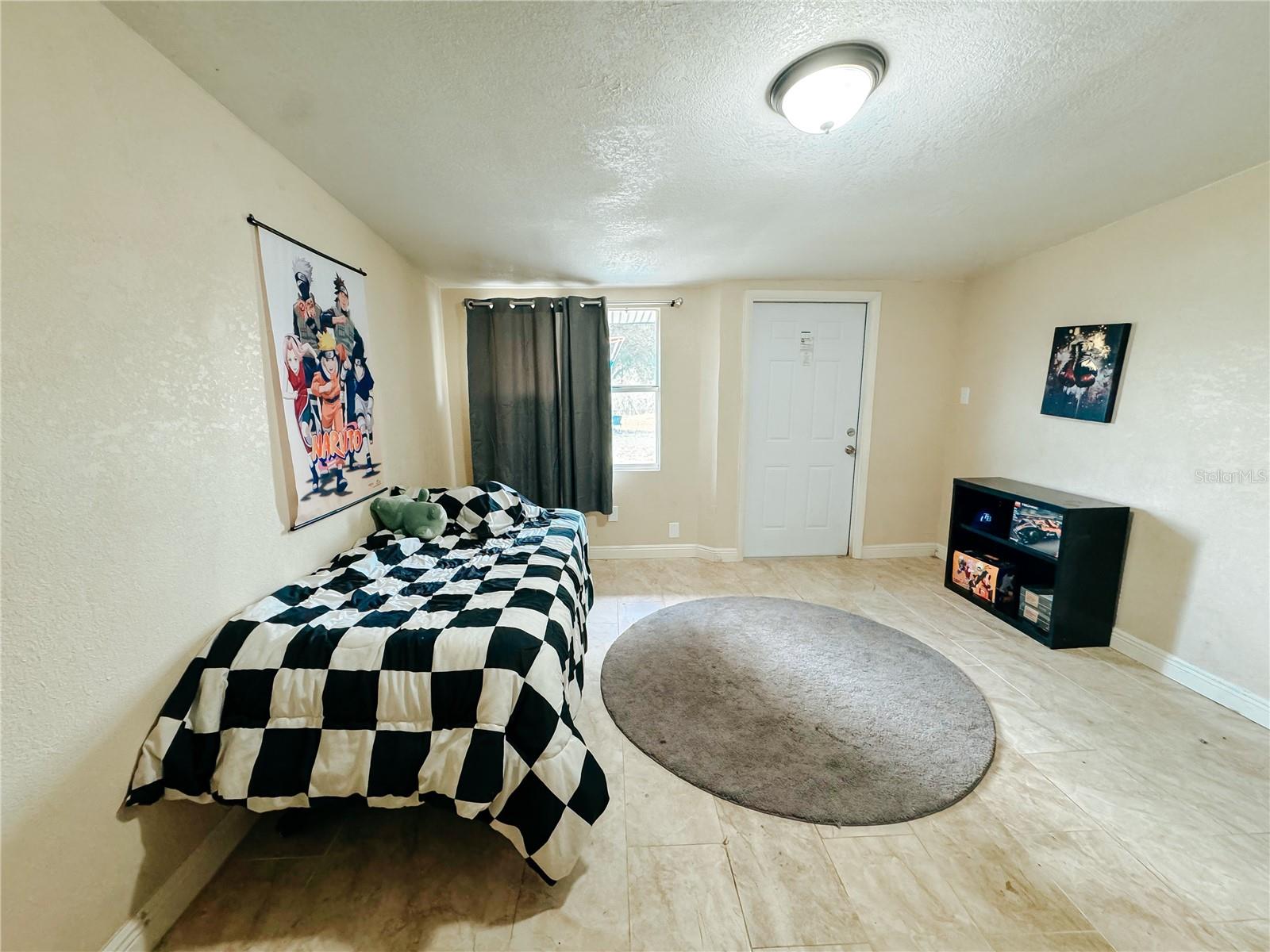 Bedroom 4 with an exterior door to the backyard as well as walk-in closet that is currently being used as a game room, there is a regular closet as well