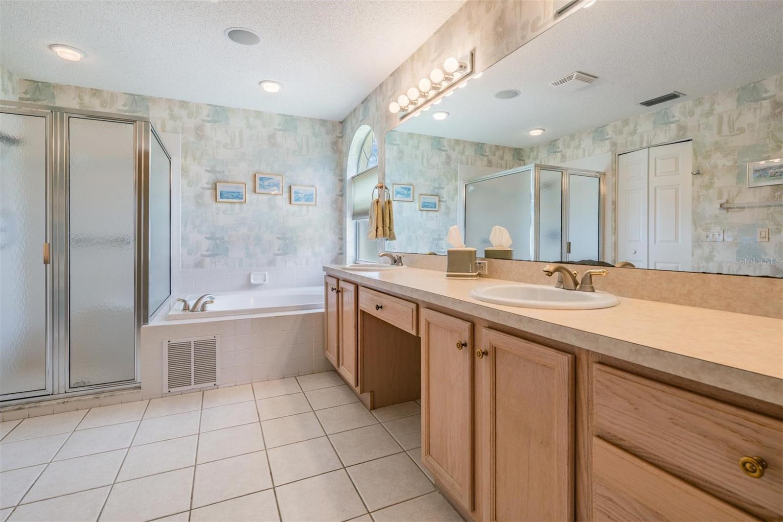 Large primary bathroom with whirlpool tub and step in shower