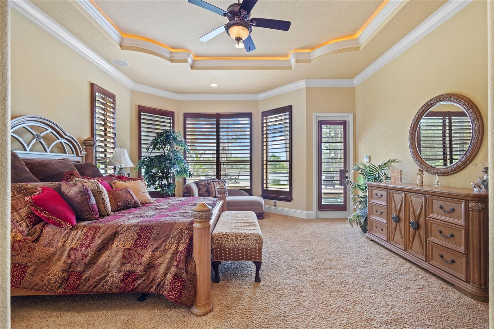 Main floor primary suite with view to pool area.