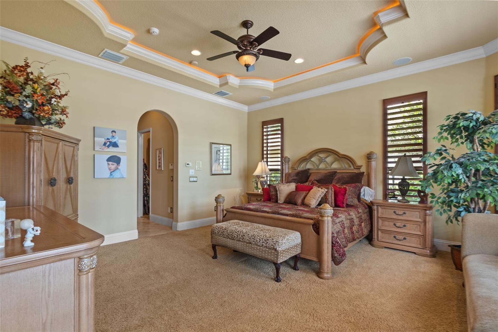 Main floor primary suite with view to pool area.