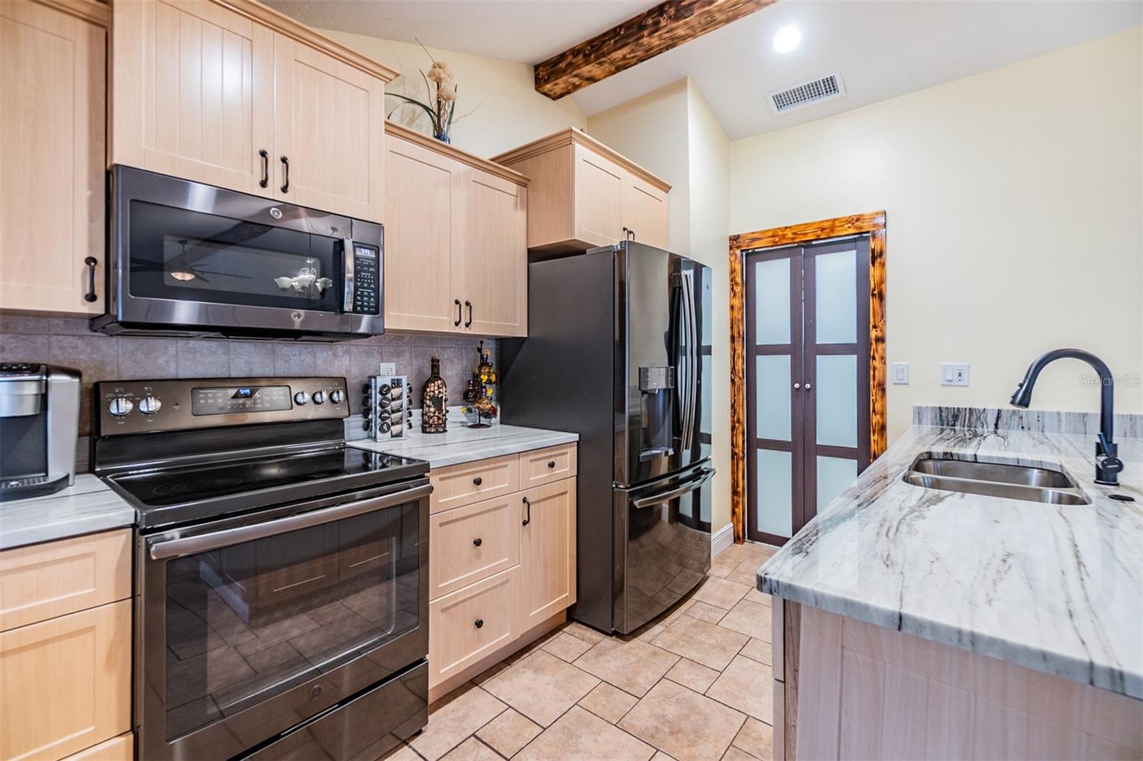 Open Kitchen, Stainless Steel Appliances, newer cabinets and Quartzite counter tops, tile flooring