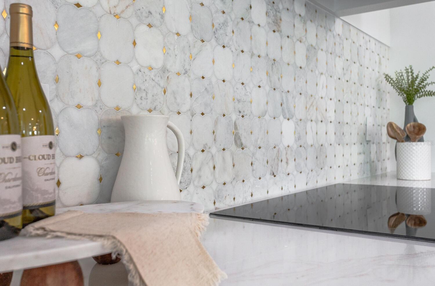 elegant backsplash with flecks of gold underline the attention to detail