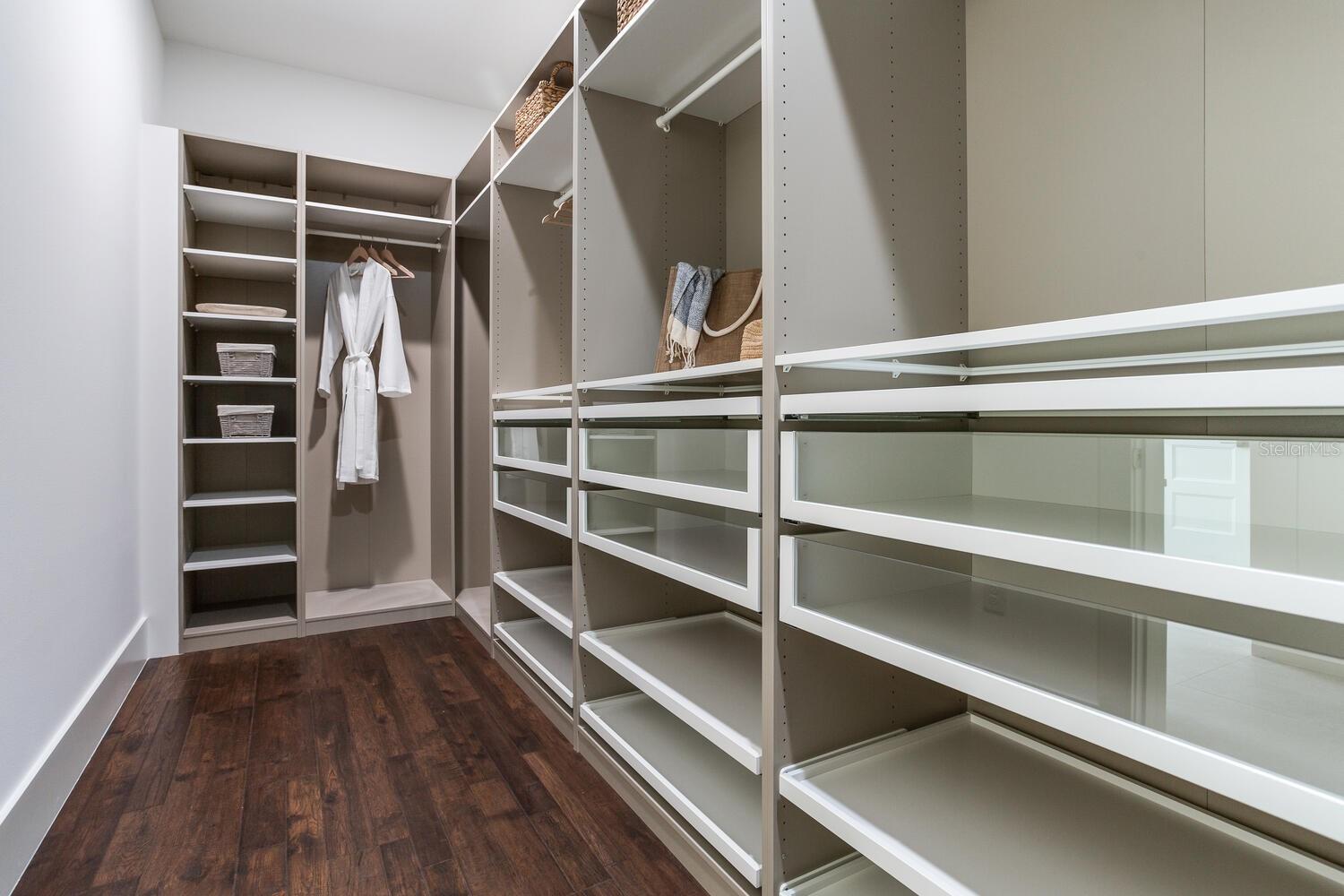 Designer custom closet is stunning with so much storage space to use while maintaining a classic, sleek look