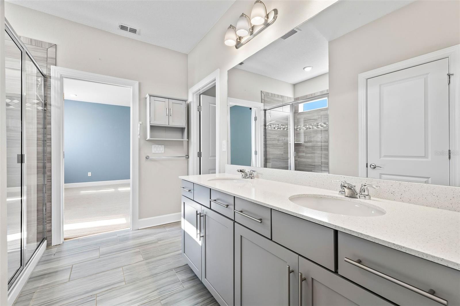 Ensuite bath to the primary with dual sinks, shower, water closet and access to the walk in closet.